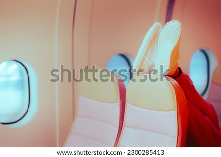 

Rude Passenger Putting her Shoes on the Seat in front. Annoying tourist making the low cost flight more uncomfortable 
 Royalty-Free Stock Photo #2300285413