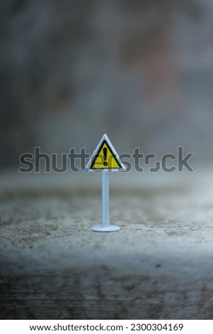 Traffic signs toy : other danger icon. Close up view on blurred gray background.