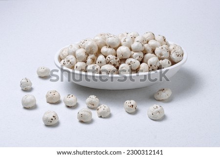 Healthy snacks Fox nuts or Protein pops called Makhana in bowl isolated on white background 
