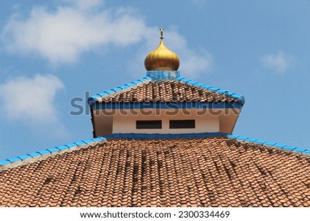 a mosque minaret against a background of blue sky and bright white clouds on a sunny morning. suitable for an Islamic building theme.