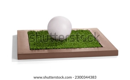 Golf ball laying on the green grass wooden frame 