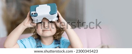 Cute little girl with vr glasses. Kid's experience with virtual reality. Looking surprised, excited, happy, smiling. Using modern gadget for playing games, watching movies, cartoons. Banner copy space