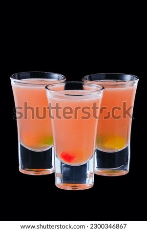 Three vodka shots with sweet jelly isolated on black background