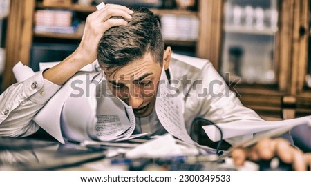 Young man desperate at work with office full of sheets and leftover work. Royalty-Free Stock Photo #2300349533