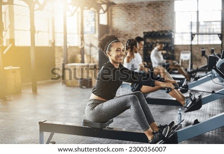 Group, rowing machine and training in gym, class or fitness workout, exercise or cardio, row team and practice. People, healthy athlete and challenge on sport equipment, row crew and sports club Royalty-Free Stock Photo #2300356007