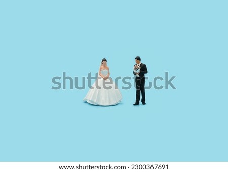 Miniature people : groom and bride on blue background Royalty-Free Stock Photo #2300367691