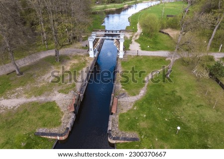 aerial view over dam lock sluice on lake impetuous waterfall Royalty-Free Stock Photo #2300370667