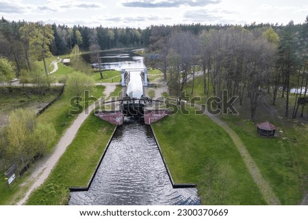 aerial view over dam lock sluice on lake impetuous waterfall Royalty-Free Stock Photo #2300370669