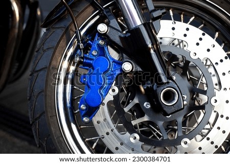 Close-up of laced wheel of motorcycle caferacer at parking lot during sunset