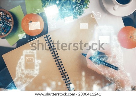 E-mail envelop theme hologram over hands taking notes background. Concept of electronic mail. Double exposure