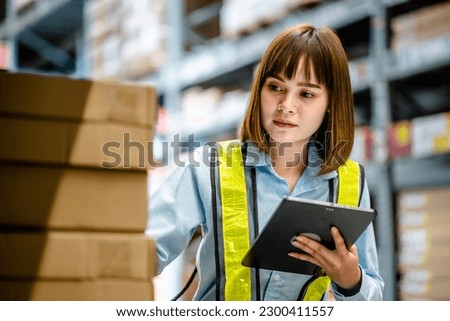 Women warehouse worker using digital tablets to check the stock inventory on shelves in large warehouses, a Smart warehouse management system, supply chain and logistic network technology concept Royalty-Free Stock Photo #2300411557