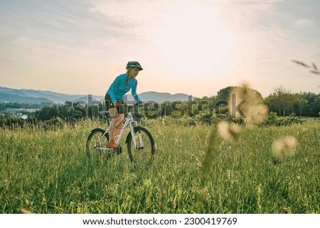 Cyclist Woman riding bike in helmets go in sports outdoors on sunny day a mountain in the forest. Silhouette female at sunset. Fresh air. Health care, authenticity, sense of balance.
