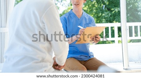 Japanese senior man listening to counseling caregiver Royalty-Free Stock Photo #2300424081