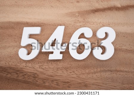White number 5463 on a brown and light brown wooden background.