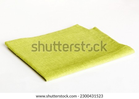 top view with green kitchen napkin isolated on table background. Folded cloth for mockup with copy space, Flat lay. Minimal style. Royalty-Free Stock Photo #2300431523