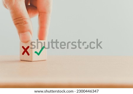 hand turn wooden cube block false to true with copy space Royalty-Free Stock Photo #2300446347