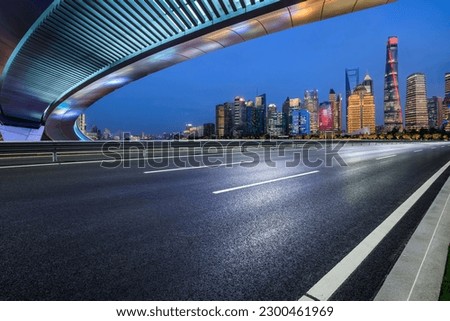 Asphalt road and city skyline with modern buildings in Shanghai at night, China.