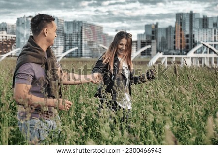 Lovely young couple having fun, woman and man together spending summertime in urban park. Caucasian couple enjoy leisure activity, outdoors. Concept of happy family relationship. Copy text space