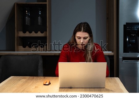 Serious woman working on computer sitting at table in cozy living room. Freelance job, remote communication, solve business, e-mailing to client distantly, web surfing information, connection concept