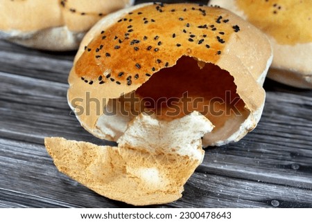 Egyptian Mahlab bread, puff thin, crispy and delicious with black seed baraka seeds on top, made of flour, dry yeast, milk, eggs, sugar, salt, black seeds, warm water, with anything or on its own Royalty-Free Stock Photo #2300478643