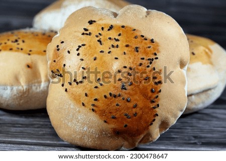 Egyptian Mahlab bread, puff thin, crispy and delicious with black seed baraka seeds on top, made of flour, dry yeast, milk, eggs, sugar, salt, black seeds, warm water, with anything or on its own Royalty-Free Stock Photo #2300478647