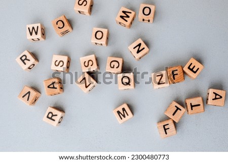 Wooden cubes with black letters on a gray table, close up. Cubes made of eco-friendly material. Top view