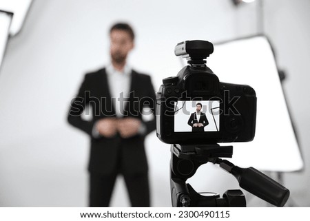 Handsome model posing for camera in modern studio, selective focus. Professional photo session