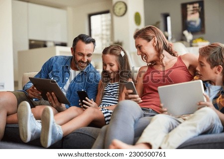 Technology, streaming and a happy family on the sofa for internet, social media and communication. Smile, bonding and a mother, father and children with a tablet and phone for online games at home Royalty-Free Stock Photo #2300500761
