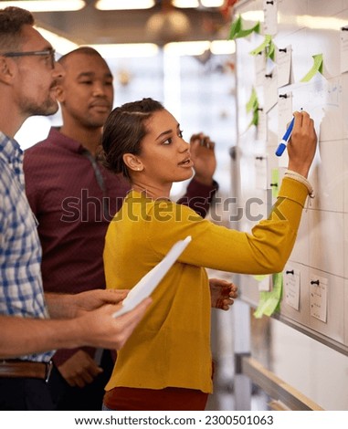 Woman, focus and brainstorm on whiteboard or marketing presentation or male employees and in office. Coach, lady trainer and man workers or flip chart or business project and workplace meeting Royalty-Free Stock Photo #2300501063