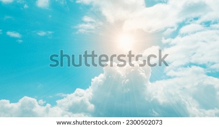 Blue sky, shining sun rays and white clouds. Hot weather background image.