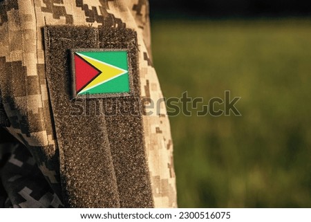 Close up millitary woman or man shoulder arm sleeve with Guyana flag patch. Troops army, soldier camouflage uniform. Armed Forces, empty copy space for text

