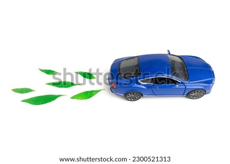 toy car and green leaf. concept of electric or green car emission isolated on white background