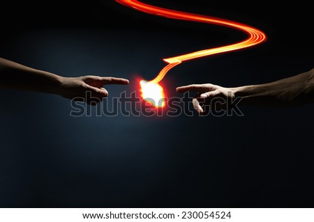 Abstract contact - Fingers affected by light waves. Light explosion from a finger. In the picture we see a human arm where the hand jumps a big "spark" of red light.
