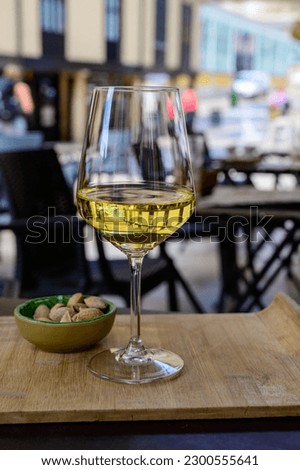 Drinking of cold spanish rueda verdejo white wine with view on old street of Oviedo, Spain