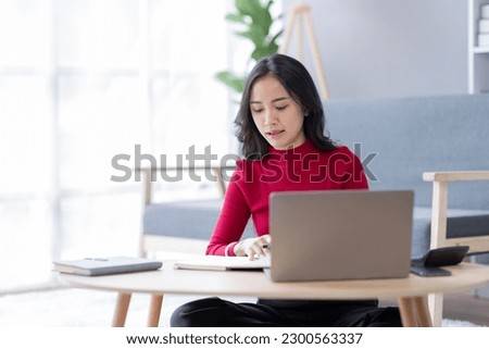 Beautiful Young asian woman at home sitting on the sofa while using laptop and headphone at home