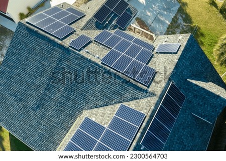 Aerial view of american home roof with blue solar photovoltaic panels for producing clean ecological electric energy. Investing in renewable electricity for retirement income Royalty-Free Stock Photo #2300564703