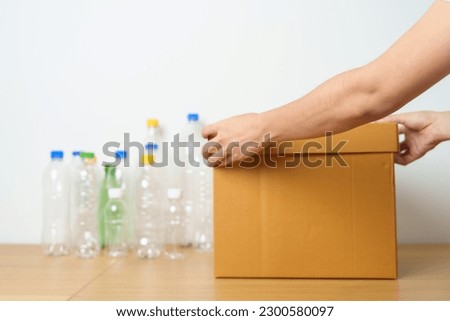 Volunteer keep plastic bottle into paper box at home or office. Hand Sorting Recycle garbage. Ecology, Environmental, pollution, Dispose recycling, waste management and trash Separation concept