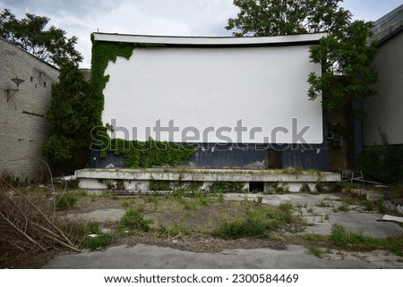 Abandoned open air cinema with white screen