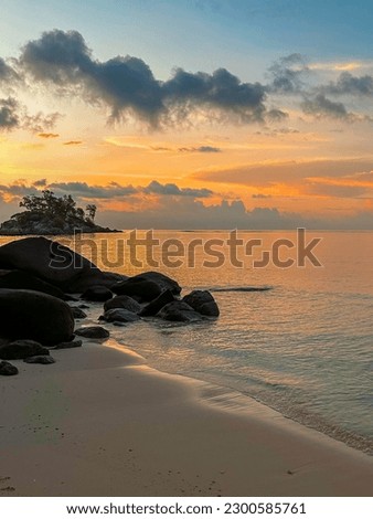 Beautiful sunrise over the ocean framed by scenic rocks on the Seychelles island of Mahe, Anse Royale beach Royalty-Free Stock Photo #2300585761