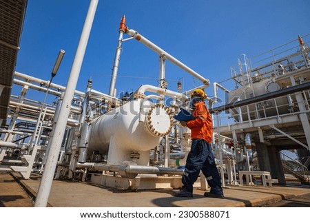 Male worker inspection at the exchanger of tank oil refinery pipeline plant steam vessel and column tank oil of Petrochemistry industry. Royalty-Free Stock Photo #2300588071