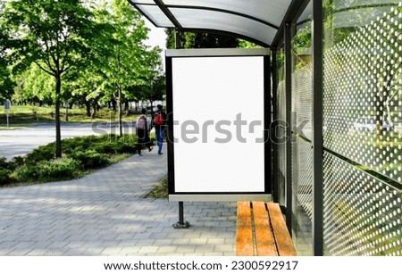 bus shelter at bus stop. transit station. blank white lightbox. empty billboard and ad placeholder. glass and aluminum structure. urban setting. city street background. stone sidewalk. base for mockup Royalty-Free Stock Photo #2300592917