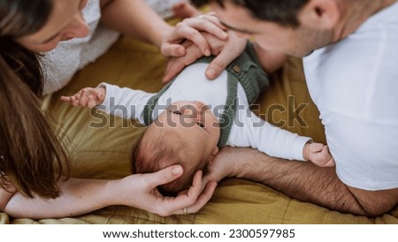 Happy parents cuddling with their newborn baby. Royalty-Free Stock Photo #2300597985