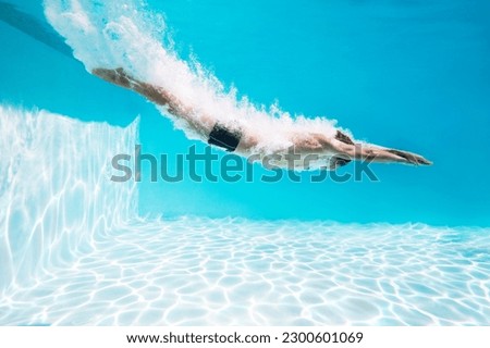 Man diving into swimming pool Royalty-Free Stock Photo #2300601069
