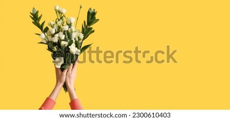 Hands of woman holding bouquet of beautiful eustoma flowers on yellow background with space for text