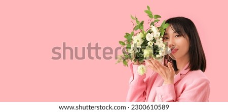 Beautiful Asian woman holding bouquet of eustoma flowers on pink background with space for text
