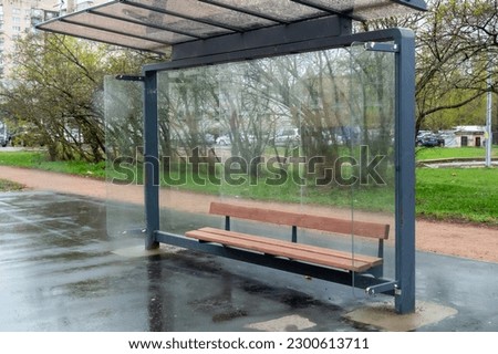 Empty bus stop complex on a rainy day Royalty-Free Stock Photo #2300613711