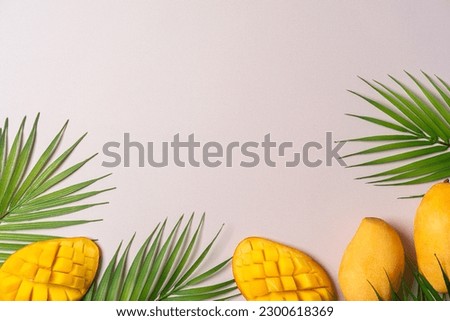 Summer colorfull concept with tropical fruits and leaves on biege background, flat lay, top view, copy space