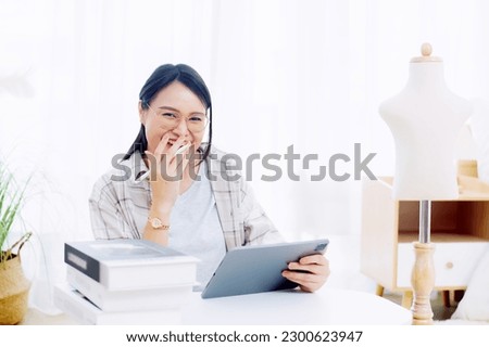 Asian woman enjoying designing clothes which is a job that she happily loves