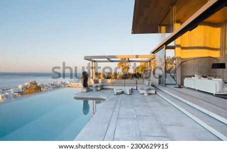 Infinity pool and patio of modern house Royalty-Free Stock Photo #2300629915