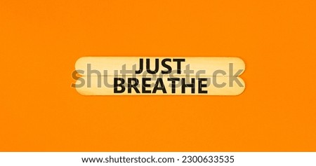Just breathe and psychological symbol. Concept words Just breathe on beautiful wooden stick. Beautiful orange table orange background. Business psychological and Just breathe concept. Copy space